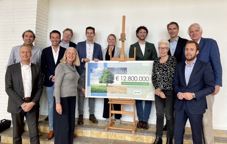 De leden van het samenwerkingsverband AGV staan trots met een cheque van 12.8 miljoen euro