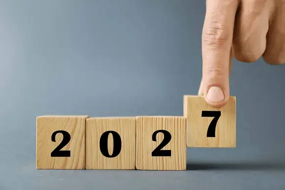 Hand completing year 2027 with wooden blocks 2026 09 30 19 23 44 utc PT